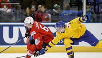 VICTORIA , BC - JANUARY 2: Marco Lehmann #6 of Switzerland skates with the puck while being chased by Adam Ginning #5 of Sweden during a quarter-final game at the IIHF World Junior Championships at the Save-on-Foods Memorial Centre on January 2, 2019 in Victoria, British Columbia, Canada. (Photo by Kevin Light/Getty Images)