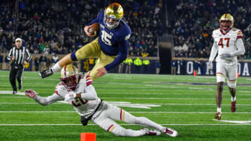 Nov 23, 2019; South Bend, IN, USA; Notre Dame Fighting Irish quarterback Phil Jurkovec (15) jumps over Boston College Eagles cornerback Elijah Jones (20) in the fourth quarter at Notre Dame Stadium. Mandatory Credit: Matt Cashore-USA TODAY Sports