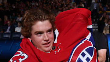 NASHVILLE, TENNESSEE - JUNE 29: Jacob Fowler puts on a jersey after being selected 69th overall by the Montreal Canadiens during the 2023 Upper Deck NHL Draft at Bridgestone Arena on June 29, 2023 in Nashville, Tennessee. (Photo by Dave Sandford/NHLI via Getty Images)