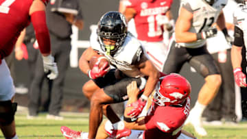 Cincinnati Bearcats wide receiver Tre Tucker is tackled by Arkansas Razorback long snapper Eli Stein. USA Today.