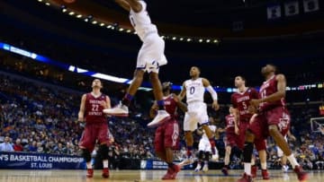 Mar 21, 2014; St. Louis, MO, USA; Kansas Jayhawks guard Andrew Wiggins (22) dunks the ball ahead of Eastern Kentucky Colonels guard Isaac McGlone (5), Glenn Cosey (0) and Marcus Lewis (12) in the first half during the 2nd round of the 2014 NCAA Men