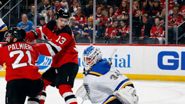 NEWARK, NJ - MARCH 30: Goalie Jake Allen #34 of the St. Louis Blues makes a save as Nico Hischier #13 of the New Jersey Devils looks over during an NHL hockey game at the Prudential Center in Newark, New Jersey. Blues won 3-2. (Photo by Paul Bereswill/Getty Images)