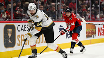 Jan 24, 2022; Washington, District of Columbia, USA; Vegas Golden Knights defenseman Nicolas Hague (14) controls the puck as Washington Capitals center Evgeny Kuznetsov (92) chases during the first period at Capital One Arena. Mandatory Credit: Brad Mills-USA TODAY Sports