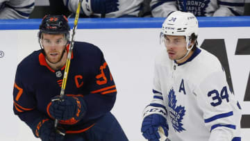 Dec 14, 2021; Edmonton, Alberta, CAN; Edmonton Oilers forward Connor McDavid (97) and Toronto Maple Leafs forward Auston Matthews (34) looks for a loose puck during the third period at Rogers Place. Mandatory Credit: Perry Nelson-USA TODAY Sports