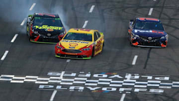 MARTINSVILLE, VA - OCTOBER 28: Joey Logano, driver of the #22 Shell Pennzoil Ford, takes the checkered flag ahead of Denny Hamlin, driver of the #11 FedEx Freight Toyota, and Martin Truex Jr., driver of the #78 5-hour ENERGY/Bass Pro Shops Toyota, to win the Monster Energy NASCAR Cup Series First Data 500 at Martinsville Speedway on October 28, 2018 in Martinsville, Virginia. (Photo by Sean Gardner/Getty Images)