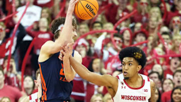 Jan 28, 2023; Madison, Wisconsin, USA; Wisconsin Badgers guard Chucky Hepburn (23) fouls Illinois Fighting Illini forward Matthew Mayer (24) during the second half at the Kohl Center. Mandatory Credit: Kayla Wolf-USA TODAY Sports