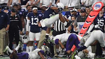 GLENDALE, AZ - DECEMBER 30: Saquon Barkley #26 of Penn State Nittany Lions leaps over defenders Austin Joyner #4 and Keishawn Bierria #7 of the Washington Huskies during the second quarter of the Playstation Fiesta Bowl at University of Phoenix Stadium on December 30, 2017 in Glendale, Arizona. Penn State won 35-28. (Photo by Norm Hall/Getty Images)