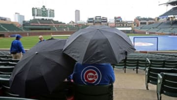 Apr 21, 2014; Chicago, IL, USA; Fans sit under umbrellas as rain falls before the game between the Chicago Cubs and the Arizona Diamondbacks at Wrigley Field. Mandatory Credit: Jerry Lai-USA TODAY Sports