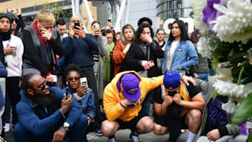 People gather around a makeshift memorial for former NBA and Los Angeles Lakers player Kobe Bryant after learning of his death at LA Live plaza in front of Staples Center in Los Angeles on January 26, 2020. - NBA legend Kobe Bryant died January 26, 2020 in a helicopter crash in suburban Los Angeles, celebrity website TMZ reported, saying five people are confirmed dead in the incident. (Photo by Frederic J. Brown / AFP) (Photo by FREDERIC J. BROWN/AFP via Getty Images)