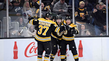 Feb 18, 2023; Boston, Massachusetts, USA; Boston Bruins left wing Jake DeBrusk (74) (middle) reacts with left wing Brad Marchand (63) and center Patrice Bergeron (37) after scoring a goal during the first period against the New York Islanders at TD Garden. Mandatory Credit: Bob DeChiara-USA TODAY Sports