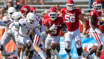 Oct 10, 2020; Dallas, Texas, USA; Oklahoma Sooners running back T.J. Pledger (5) breaks through the defensive line of Texas Longhorns during the Red River Showdown at Cotton Bowl. Mandatory Credit: Andrew Dieb-USA TODAY Sports