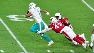 Nov 8, 2020; Glendale, Arizona, USA; Miami Dolphins quarterback Tua Tagovailoa (1) slips a tackle by Arizona Cardinals outside linebacker Haason Reddick (43) and linebacker Isaiah Simmons (48) during the second half at State Farm Stadium. Mandatory Credit: Matt Kartozian-USA TODAY Sports