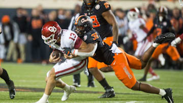 Nov 27, 2021; Stillwater, Oklahoma, USA; Oklahoma State Cowboys defensive end Collin Oliver (30) sacks Oklahoma Sooners quarterback Caleb Williams (13) during the fourth quarter at Boone Pickens Stadium. Oklahoma State won 37-33. Mandatory Credit: Brett Rojo-USA TODAY Sports