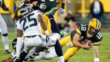 Sep 20, 2015; Green Bay, WI, USA; Green Bay Packers quarterback Aaron Rodgers (12) scrambles against Seattle Seahawks linebacker Bobby Wagner (54) and cornerback Richard Sherman (25) in the third quarter at Lambeau Field. Mandatory Credit: Benny Sieu-USA TODAY Sports