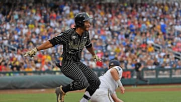 Austin Martin #16 of the Vanderbilt Commodores gets thrown out at first base. (Photo by Peter Aiken/Getty Images)