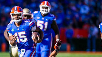 Florida Gators quarterback Anthony Richardson (15) evades a tackle by Florida State Seminoles defensive end Jermaine Johnson II (11) in the second half. The Florida Gators defeated the Florida State Seminoles 24-21 Saturday November 27, 2021 at Ben Hill Griffin Stadium in Gainesville, Florida. [Doug Engle/Ocala Star-Banner]2021Flgai 112721 Ufvsfsu Fb