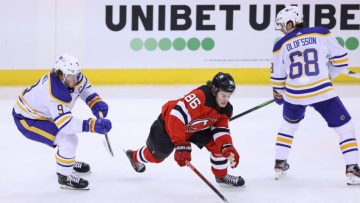 Feb 23, 2021; Newark, New Jersey, USA; New Jersey Devils center Jack Hughes (86) reaches for the puck in front of Buffalo Sabres center Jack Eichel (9) and right wing Victor Olofsson (68) during the first period at Prudential Center. Mandatory Credit: Vincent Carchietta-USA TODAY Sports
