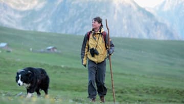 MALLES VENOSTA, ITALY - JULY 28: Katharina Brueggebors scans the meadows for lost and injured cattle with her sheepdog on her daily circuit on July 28, 2013 at the Sesvenna Alpe near Malles Venosta (Mals), Italy. As herdswoman she watches over the herd of 300 cattle that she is overseeing for the summer months during the traditional alm summer livestock grazing. Brueggebors, a former hotel chain manager, has no experience in farming but hopes the calm and quiet six months in the Alps living in a traditional alm, which is a small wooden mountain cottage, will provide will help her in reorienting her life. Alm livestock herders regularly hire inexperienced help from many walks of life to help in the summer months, when farmers in valley villages commission the herders to bring the animals up to mountain plateaus to spend the summer months feeding on the grass-rich meadows. Alm tradition in the mountains of Switzerland, Austria, northern Italy and southern Germany goes back centuries and is an integral part of alpine life and agriculture. (Photo by Johannes Simon/Getty Images)