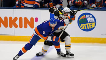 Jan 18, 2021; Uniondale, New York, USA; New York Islanders defenseman Adam Pelech (3) and Boston Bruins center Brad Marchand (63) battle for the puck during the third period at Nassau Veterans Memorial Coliseum. Mandatory Credit: Dennis Schneidler-USA TODAY Sports