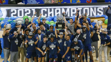 Mar 13, 2021; Greensboro, North Carolina, USA; The Georgia Tech Yellow Jackets lift the trophy after defeating the Florida State Seminoles 80-75 to win the 2021 ACC tournament championship at Greensboro Coliseum. Mandatory Credit: Nell Redmond-USA TODAY Sports