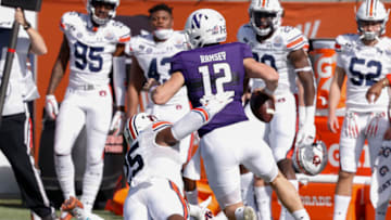 Auburn footballJan 1, 2021; Orlando, FL, USA; Northwestern Wildcats quarterback Peyton Ramsey (12) eludes the grasp of Auburn Tigers linebacker Colby Wooden (25) during the first quarter at Camping World Stadium. Mandatory Credit: Reinhold Matay-USA TODAY Sports