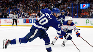 Nov 8, 2022; Tampa, Florida, USA; Tampa Bay Lightning right wing Corey Perry (10) passes the puck as Edmonton Oilers right wing Kailer Yamamoto (56) defends during the first period at Amalie Arena. Mandatory Credit: Kim Klement-USA TODAY Sports