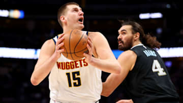 DENVER, CO - DECEMBER 20: Nikola Jokic #15 of the Denver Nuggets drives past Steven Adams #4 of the Memphis Grizzlies in the first quarter at Ball Arena on December 20, 2022 in Denver, Colorado. NOTE TO USER: User expressly acknowledges and agrees that, by downloading and or using this photograph, User is consenting to the terms and conditions of the Getty Images License Agreement. (Photo by Jamie Schwaberow/Getty Images)