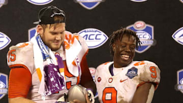CHARLOTTE, NC - DECEMBER 01: Mitch Hyatt #75 and teammate Travis Etienne #9 of the Clemson Tigers hold the ACC Championship trophy after their 42-10 victory over the Pittsburgh Panthers at Bank of America Stadium on December 1, 2018 in Charlotte, North Carolina. (Photo by Streeter Lecka/Getty Images)