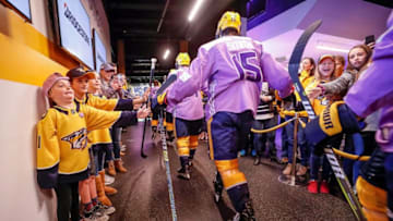 NASHVILLE, TN - NOVEMBER 3: Hockey Fights Cancer kid Gwyne Roark high fives Craig Smith #15 of the Nashville Predators prior to an NHL game against the Boston Bruins at Bridgestone Arena on November 3, 2018 in Nashville, Tennessee. (Photo by John Russell/NHLI via Getty Images)