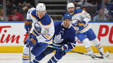 TORONTO, ON - APRIL 12: Rasmus Dahlin #26 of the Buffalo Sabres skates with the puck against Alexander Kerfoot #15 of the Toronto Maple Leafs during an NHL game at Scotiabank Arena on April 12, 2022 in Toronto, Ontario, Canada. The Sabres defeated the Maple Leafs 5-2. (Photo by Claus Andersen/Getty Images)