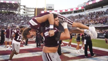 Oct 1, 2022; Starkville, Mississippi, USA; Mississippi State Bulldogs offensive lineman Cole Smith (57) carries quarterback Will Rogers (2) after the victory against Texas A&M Aggies at Davis Wade Stadium at Scott Field. Mandatory Credit: Matt Bush-USA TODAY Sports