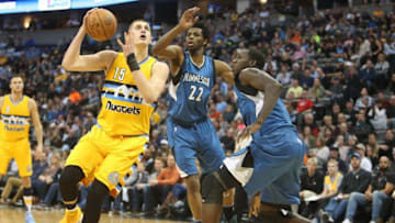 Dec 28, 2016; Denver, CO, USA; Denver Nuggets forward Nikola Jokic (15) shoots the ball against Minnesota Timberwolves forwards Gorgui Dieng (right) and Andrew Wiggins (22) during the first half at Pepsi Center. Mandatory Credit: Chris Humphreys-USA TODAY Sports