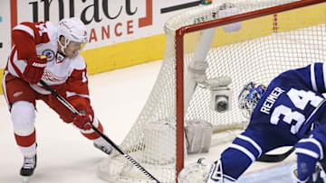 Nov 6, 2015; Toronto, Ontario, CAN; Toronto Maple Leafs goalie James Reimer (34) makes a save against the post as Detroit Red Wings right wing Gustav Nyquist (14) tries to jam the puck into the net in overtime at Air Canada Centre. The Red Wings beat the Maple Leafs 2-1. Mandatory Credit: Tom Szczerbowski-USA TODAY Sports