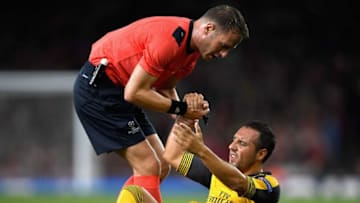 LONDON, ENGLAND - SEPTEMBER 28: Santi Cazorla of Arsenal is helped to his feet by referee Danny Makkelie during the UEFA Champions League group A match between Arsenal FC and FC Basel 1893 at the Emirates Stadium on September 28, 2016 in London, England. (Photo by Mike Hewitt/Getty Images)