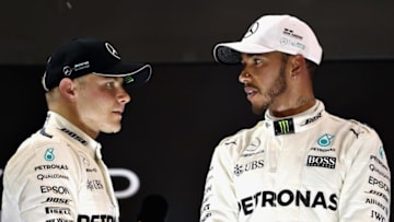 ABU DHABI, UNITED ARAB EMIRATES - NOVEMBER 26: Race winner Valtteri Bottas of Finland and Mercedes GP talks with second place finisher Lewis Hamilton of Great Britain and Mercedes GP on the podium during the Abu Dhabi Formula One Grand Prix at Yas Marina Circuit on November 26, 2017 in Abu Dhabi, United Arab Emirates. (Photo by Mark Thompson/Getty Images)