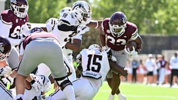 Oct 7, 2023; Starkville, Mississippi, USA; Mississippi State Bulldogs running back Seth Davis (23) runs the ball while defended by Western Michigan Broncos defensive lineman Joshua Nobles (98) and linebacker Donald Willis (15) during the fourth quarter at Davis Wade Stadium at Scott Field. Mandatory Credit: Matt Bush-USA TODAY Sports