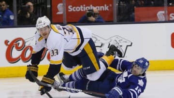 Nov 18, 2014; Toronto, Ontario, CAN; Nashville Predators forward Colin Wilson (33) goes over top of Toronto Maple Leafs defenceman Stephane Robidas (12) after a pass to Nashville Predators forward Calle Jarnkrok (not pictured) at the Air Canada Centre. Nashville defeated Toronto 9-2. Mandatory Credit: John E. Sokolowski-USA TODAY Sports