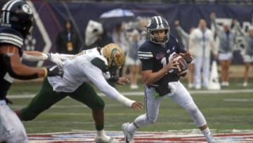 Dec 18, 2021; Shreveport, LA, USA; BYU Cougars quarterback Baylor Romney (16) avoids UAB Blazers linebacker Alex Wright (16) during the first quarter during the 2021 Independence Bowl at Independence Stadium. Mandatory Credit: Petre Thomas-USA TODAY Sports
