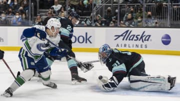 Jan 1, 2022; Seattle, Washington, USA; Vancouver Canucks left wing Nils Hoglander (21) scores a power play goal against Seattle Kraken goalkeeper Philipp Grubauer (31) during the first period at Climate Pledge Arena. Mandatory Credit: Stephen Brashear-USA TODAY Sports