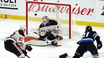 Kyle Connor #81, Winnipeg Jets; Mike Smith #41, Edmonton Oilers. (Photo by David Lipnowski/Getty Images)