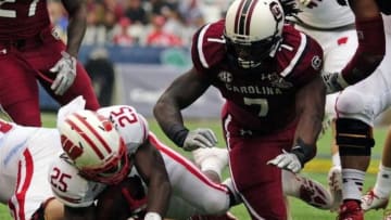 Jan 1, 2014; Orlando, FL, USA; South Carolina Gamecocks defensive end Jadeveon Clowney (7) knocks down Wisconsin Badgers running back Melvin Gordon (25) in the first quarter as the South Carolina Gamecocks face the Wisconsin Badgers in the Capital One Bowl at Florida Citrus Bowl. Mandatory Credit: David Manning-USA TODAY Sports