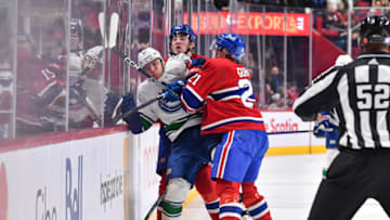 MONTREAL, CANADA - NOVEMBER 09: Andrei Kuzmenko #96 of the Vancouver Canucks is caught between Kaiden Guhle #21 and teammate Kirby Dach #77 of the Montreal Canadiens during the first period at Centre Bell on November 9, 2022 in Montreal, Quebec, Canada. (Photo by Minas Panagiotakis/Getty Images)