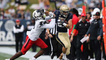 Cincinnati Bearcats Ja'von Hicks pushes Navy Midshipmen's Kai Puailoa-Rojas out of bounds. The Enquirer.