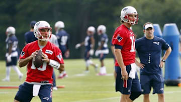 Jun 7, 2016; Foxborough, MA, USA; New England Patriots quarterback Jimmy Garoppolo (10) drops back to pass as offensive coordinator Josh McDaniels and quarterback Tom Brady (12) look on during mini camp at Gillette Stadium. Mandatory Credit: Winslow Townson-USA TODAY Sports