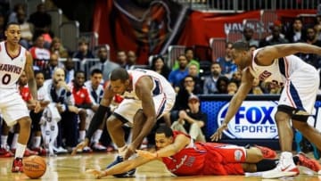 Dec 4, 2013; Atlanta, GA, USA; Atlanta Hawks power forward Paul Millsap (4) and Los Angeles Clippers center Ryan Hollins (15) reach for a loose ball in the first half at Philips Arena. Mandatory Credit: Daniel Shirey-USA TODAY Sports