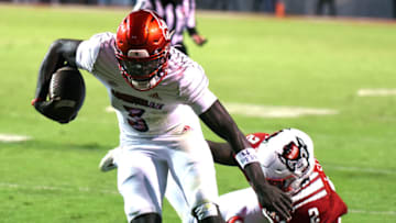 Louisville Cardinals quarterback Malik Cunningham (3) rungs the ball during the first half against the North Carolina State Wolfpack at Carter-Finley Stadium. Mandatory Credit: Rob Kinnan-USA TODAY Sports