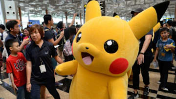 Fans gather to watch the Pokemon Go virtual reality game mascot Pikachu parade during a promotional event at the Changi International airport terminal in Singapore on November 18, 2016.Hundreds of Pokemon fans gathered at Changi Airport's Terminal 3 on November 18 to watch the Pikachu parade and Gingerbread House display which are part of the airport's year-end events. / AFP / Roslan RAHMAN (Photo credit should read ROSLAN RAHMAN/AFP/Getty Images)