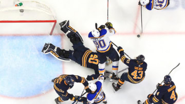 BUFFALO, NY - MARCH 17: Ryan O'Reilly #90 of the St. Louis Blues falls over goaltender Carter Hutton #40 of the Buffalo Sabres prior to a goal by Brayden Schenn #10 of the Blues during an NHL game on March 17, 2019 at KeyBank Center in Buffalo, New York. Buffalo won 4-3 in a shootout. (Photo by Bill Wippert/NHLI via Getty Images)