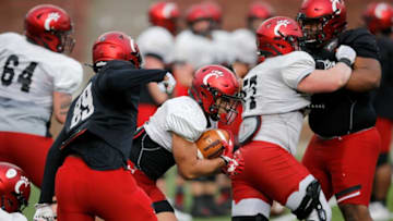 The Cincinnati Bearcats run plays during a spring practice at Nippert Stadium. The Enquirer.
