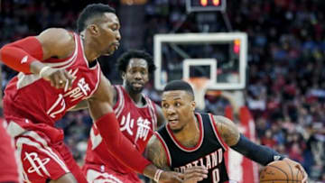 Feb 6, 2016; Houston, TX, USA; Portland Trail Blazers guard Damian Lillard (0) dribbles against Houston Rockets center Dwight Howard (12) in the second half at Toyota Center. Portland won 96 to 79. Mandatory Credit: Thomas B. Shea-USA TODAY Sports